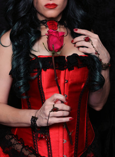 Femme en corset rouge avec rose rouge - Photo, image
