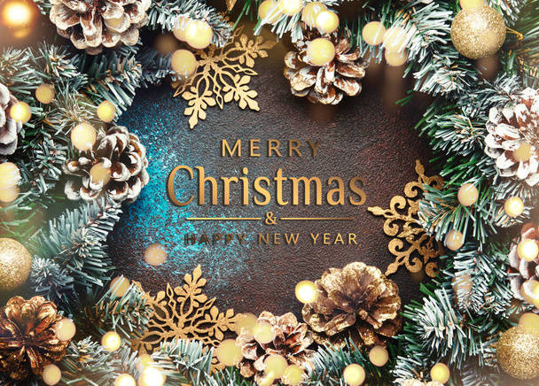 Merry Christmas and Happy New Year background with text. Green snow fir branches, pine cones, golden snowflakes, Christmas balls on brown background, top view - 写真・画像
