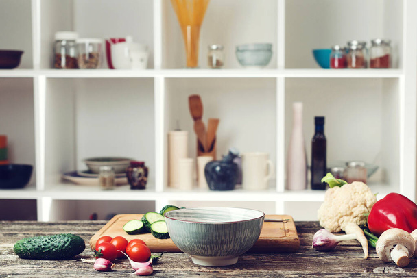 Food cooking background with vegetables. Vegetarian cuisine ingredients at kitchen counter. Blurred kitchen background. Healthy food and diet concept. Vegetables on the wooden boart. - 写真・画像