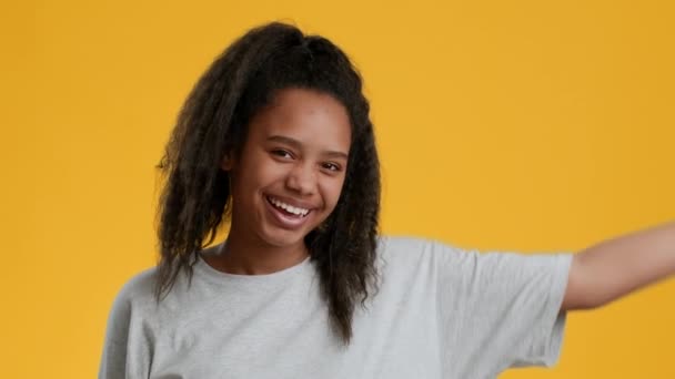 Vrolijk zwart tiener meisje Gesturing duimen omhoog over gele achtergrond - Video