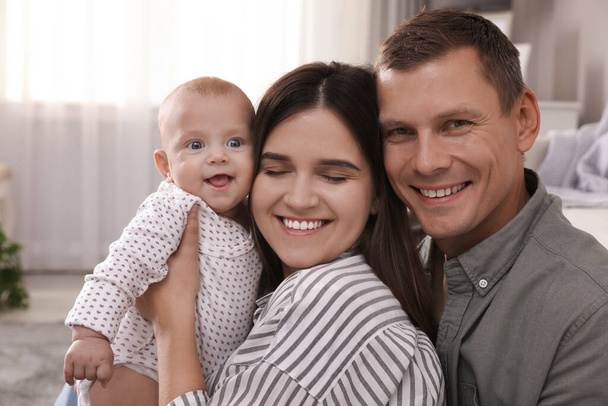 Happy family with their cute baby in living room at home - Zdjęcie, obraz