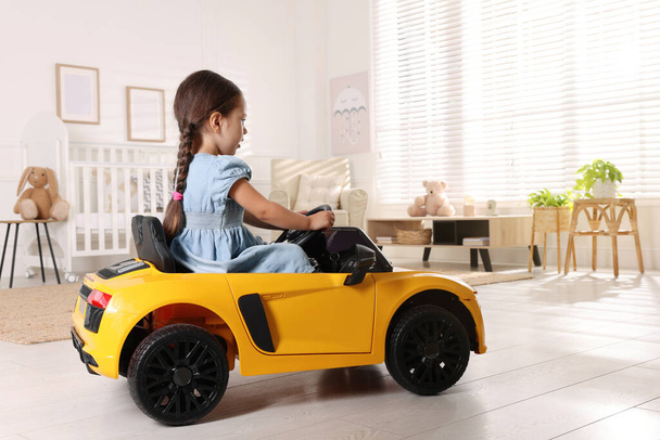 Adorable child driving toy car in room at home - Foto, Bild