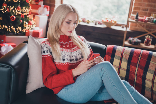 Portrait of attractive focused lonely girl sitting on divan using device gadget blogging at modern loft industrial style indoors - Photo, image
