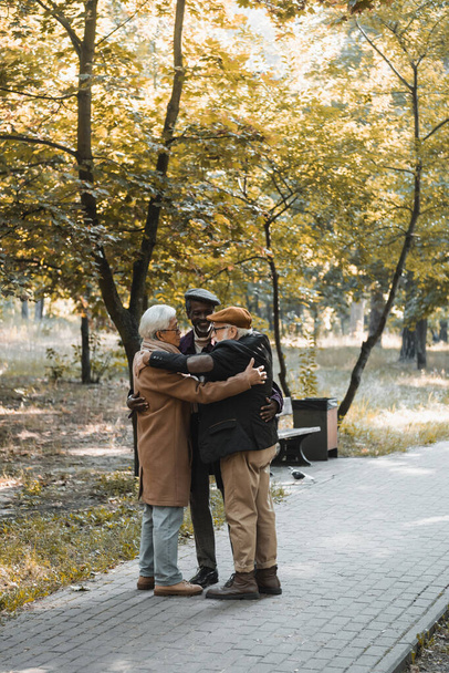 Pozitív multikulturális barátok ölelkeznek az őszi parkban  - Fotó, kép