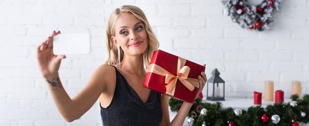 Посмішка жінки, яка робить самовіддані подарунки в прикрашеній вітальні, банер. - Фото, зображення