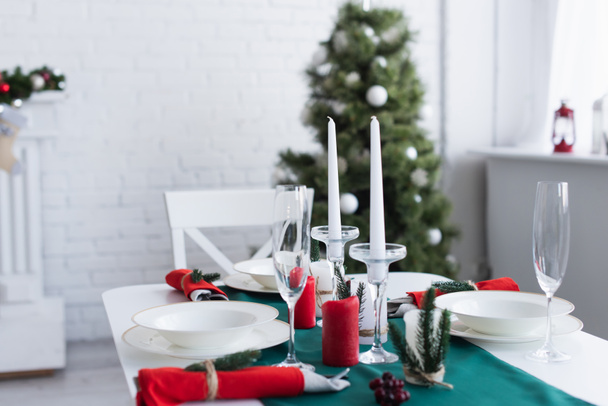 table served for festive dinner near christmas tree on blurred background - Photo, image