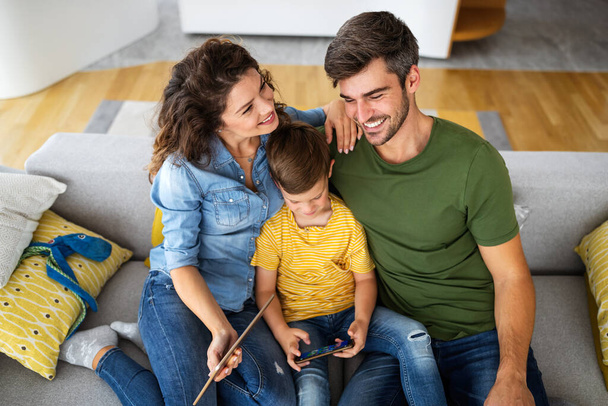 Happy family using technology devices together at home. People, education concept. - Fotoğraf, Görsel