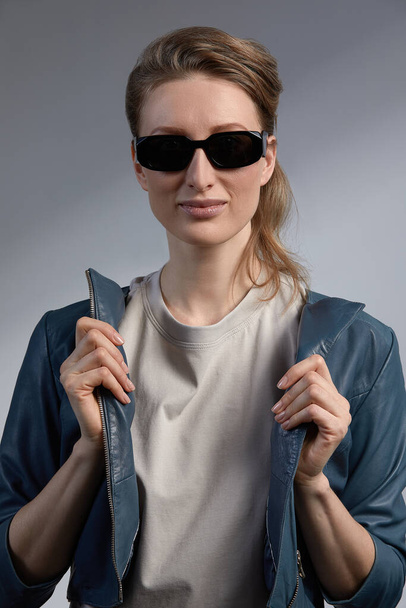 Сумасшедшая женщина в солнечных очках показывает язык рок на жесте признаки положительных эмоций. - Фото, изображение