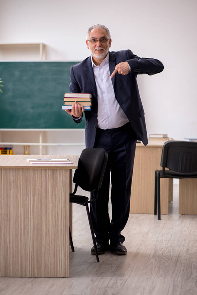Old male teacher in front of blackboard - Zdjęcie, obraz
