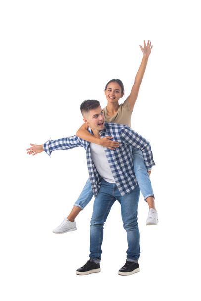Laughing teen playful couple piggyback ride isolated white background - Foto, afbeelding