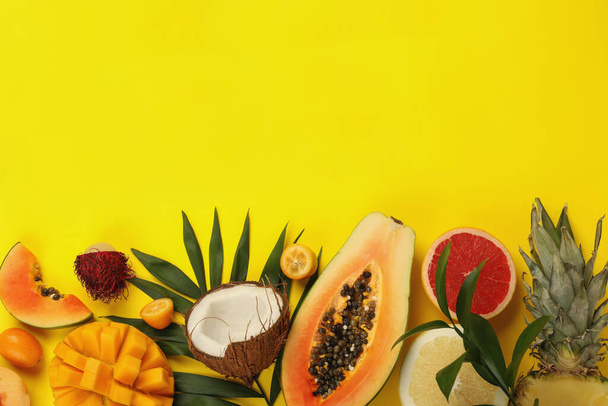 Εξωτικά φρούτα σε κίτρινο φόντο, χώρος για κείμενο. - Φωτογραφία, εικόνα