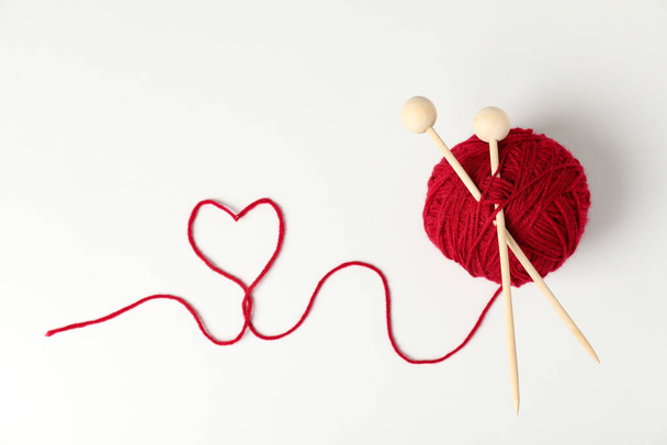 Bola vermelha de fios e agulhas de tricô sobre fundo branco - Foto, Imagem