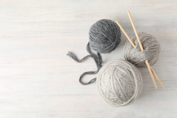 Yarn balls and knitting needles on white wooden table. - Photo, Image