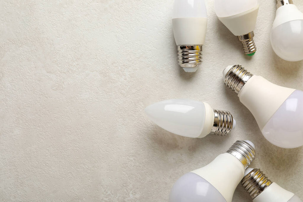 Energy saving bulbs on white textured background. - Φωτογραφία, εικόνα