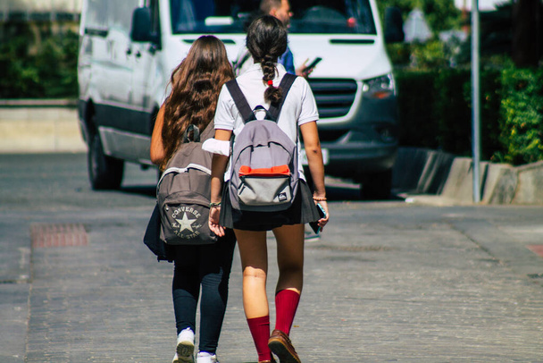 Севілья Іспанія 22 вересня 2021 року Шкільна дівчинка, яка йде по вулиці під час спалаху коронавірусу в Іспанію, носіння маски не є обов'язковим, але більшість людей носять її. - Фото, зображення
