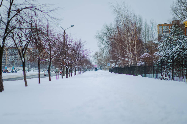 Niewypolerowane chodniki po zimowych opadach śniegu. Droga jest pokryta głębokim śniegiem. Ścieżki deptane w śniegu. - Zdjęcie, obraz