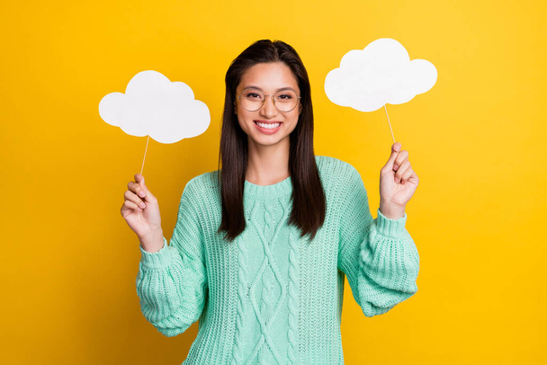 Photo of charming happy young woman wear glasses hold hands clouds weather isolated on yellow color background - Foto, afbeelding