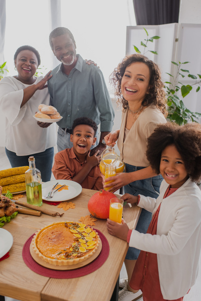 Familia afroamericana positiva celebrando Acción de Gracias con abuelos en casa  - Foto, imagen