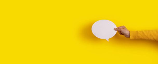 Talk burbuja icono de voz en la mano sobre fondo amarillo, diseño panorámico - Foto, imagen