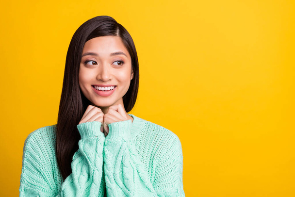 Photo of sweet adorable young lady wear turquoise sweater smiling arms chin looking empty space isolated yellow color background - Foto, imagen