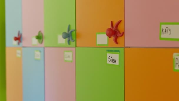 Kinderen naamplaatjes in kleuterschoolkluisjes. Het veranderen van focus van gekleurde deuren met namen van kinderen. - Video