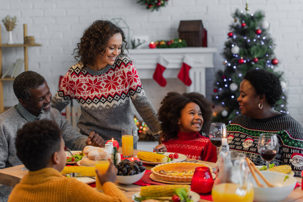 african american family smiling during christmas dinner at home - Zdjęcie, obraz