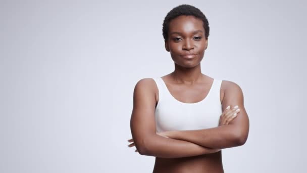 Koncept sebedůvěry. Mladý sebevědomý africký Američan žena přes ruce a usmívá se na kameru, prázdný prostor - Záběry, video