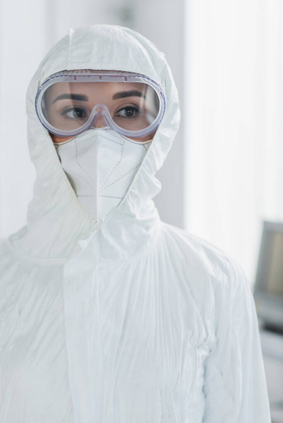 doctor in personal protective equipment and goggles looking away - Фото, зображення