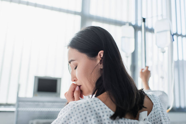 хвора жінка із закритими очима відчуває біль під час терапії в лікарні
 - Фото, зображення