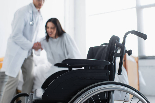 modern wheelchair near doctor with patient on blurred background  - Фото, изображение