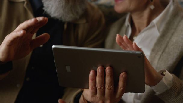 Primer plano de la computadora de la tableta en manos de viejos pares que tienen videollamada. Chat en línea - Foto, imagen