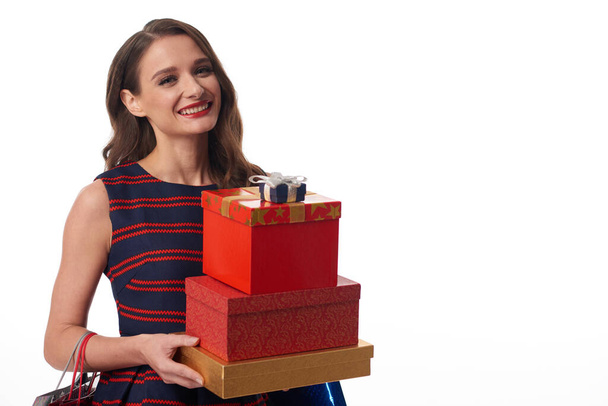 Joven mujer sonriente llevando regalos - Foto, imagen