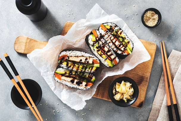 onigirazu sushi sandwich with vegan tofu filling marinated with soy sauce, sweet potatoes and avocado - Фото, изображение