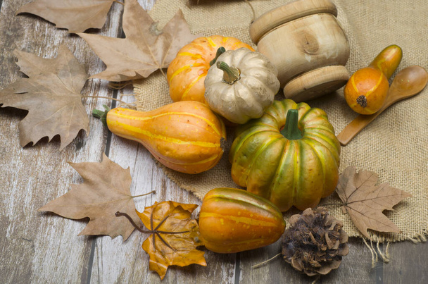 herfst stilleven. pompoenen en bladeren op rustieke houten ondergrond - Foto, afbeelding