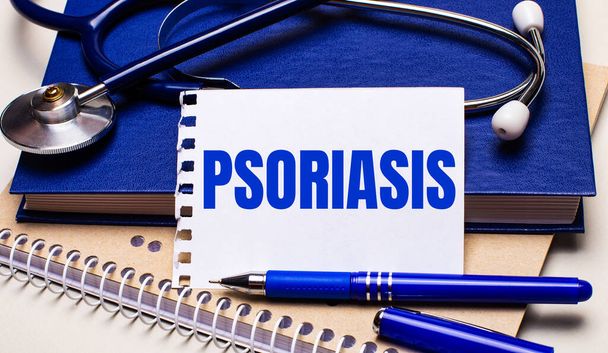 On the table are notepads, a stethoscope, a pen and a sheet of paper with the text PSORIASIS. Medical concept - Fotoğraf, Görsel