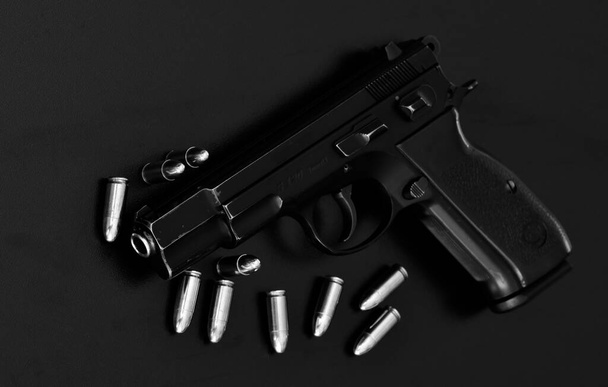 photo d'un pistolet noir et des balles sur un fond noir - Photo, image