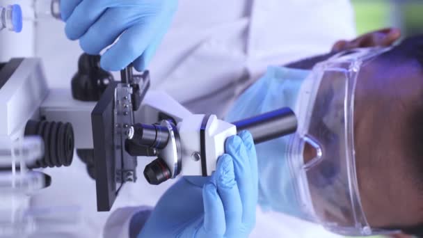 Медленное движение индийского ученого с помощью микроскопа в лаборатории  - Кадры, видео