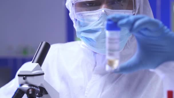 Gözlüklü ve tıbbi maskeli Hintli bilim adamı laboratuarda koronavirüs aşısı tutuyor.  - Video, Çekim