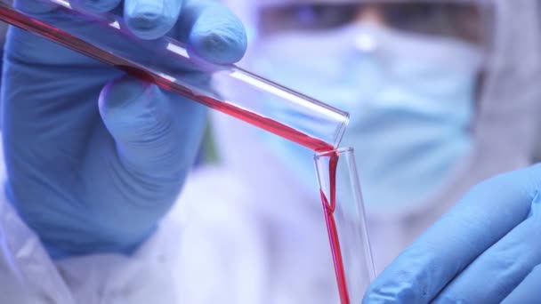 Wazig wetenschapper in latex handschoenen gieten bloed in reageerbuis  - Video