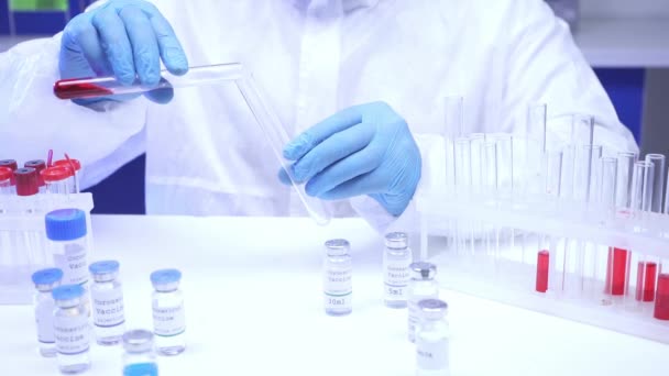 Ausgeschnittene Ansicht eines Wissenschaftlers, der in der Nähe von Impfstoffen im Labor Blut in Reagenzglas gießt  - Filmmaterial, Video