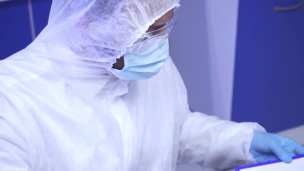 Індійський вчений у медичній масці кладе дошку в лабораторію.  - Кадри, відео