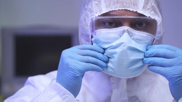 Cientista indiano em terno hazmat ajustando máscara médica em laboratório  - Filmagem, Vídeo