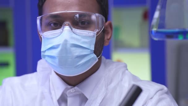 Científico indio quitándose las gafas de seguridad en laboratorio  - Metraje, vídeo