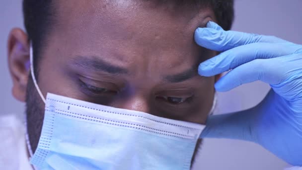 Scienziato indiano concentrato in guanto di lattice e maschera medica in laboratorio  - Filmati, video