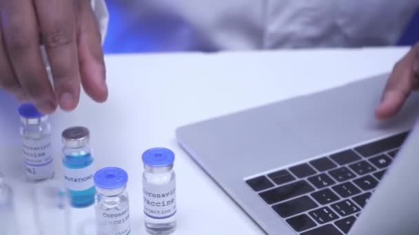 Viljelty näkymä tiedemies käyttää kannettavaa tietokonetta ja ottaen coronavirus rokotteen lab  - Materiaali, video