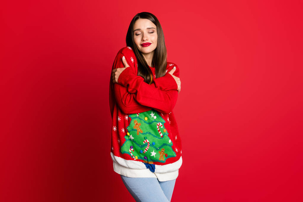 Photo of inspired dreamy lady hands embrace shoulders wear decorated sweater isolated on red color background - Фото, зображення