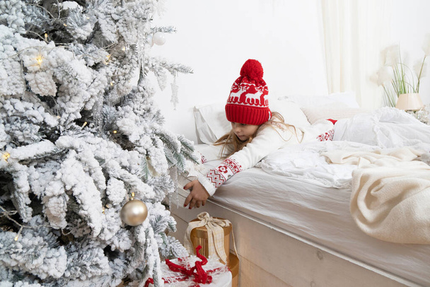 En la mañana de Navidad, un niño encontró regalos bajo el árbol. - Foto, Imagen