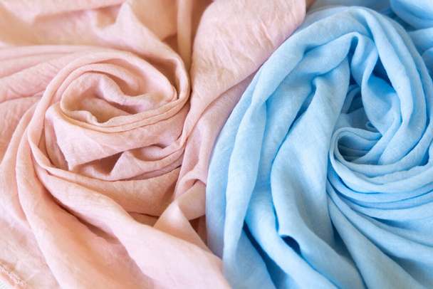 Két színű ruhás kisfiú és kislány. Puha muszlin baba takaró háttér. Pamut ruhák és textíliák. Természetes szerves szövet textúra. Világos rózsaszín és kék szín. Közelről.. - Fotó, kép