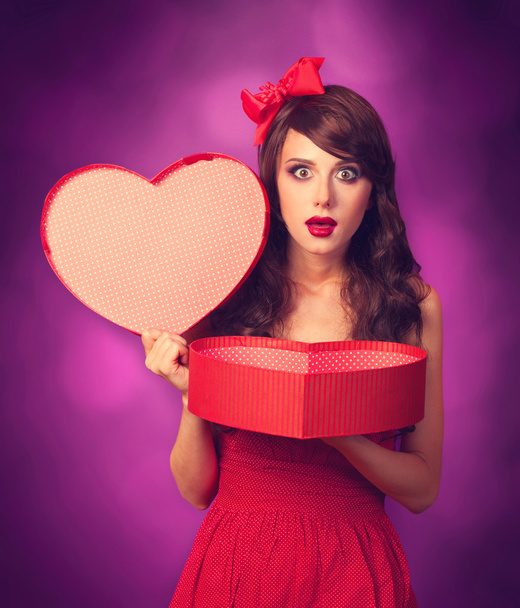 Belle fille brune avec un cadeau en forme de coeur sur backgrou violet
 - Photo, image