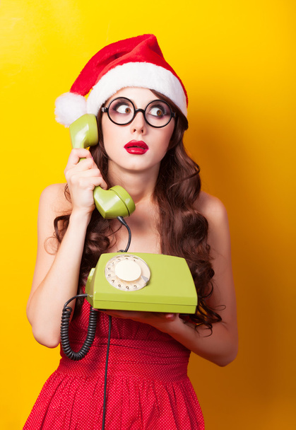 Belle fille brune en chapeau de Noël avec téléphone sur yello
 - Photo, image